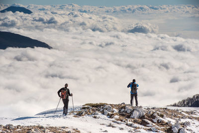 Man standing on snow covered mountain against sky