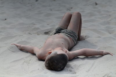 Low section of woman relaxing at beach