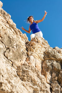 Low angle view of woman sitting on rock