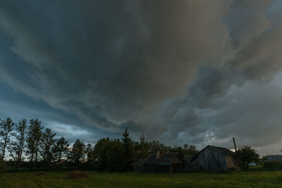 Houses and trees against cloudy sky