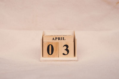 Close-up of information sign on table against wall