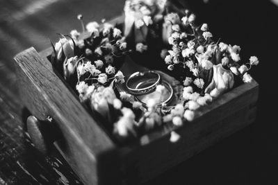 Close-up of wedding rings with flowers in box on table