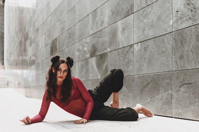 Full length of woman dancing on floor against wall