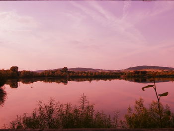 Scenic view of lake against sky at sunset