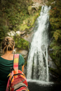 Rear view of woman against waterfall