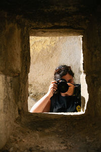 Portrait of man photographing against wall