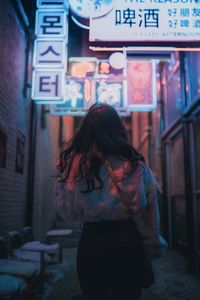 Midsection of woman standing by sign in city