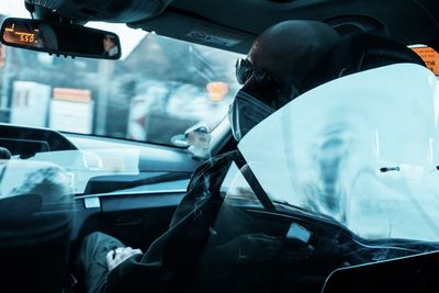 Man seen through car windshield