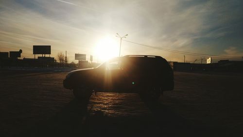 Silhouette man in city against sky during sunset