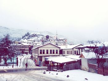 Houses in city against sky during winter