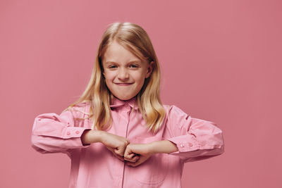 Portrait of young woman with arms crossed standing against yellow background