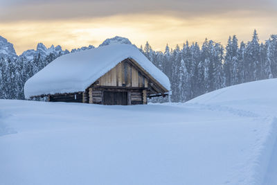 Houses on snow covered land against sky