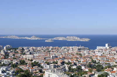 High angle view of townscape by sea against sky