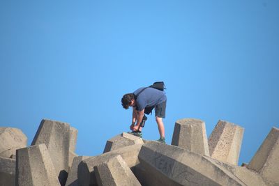 Low angle view of man against blue sky