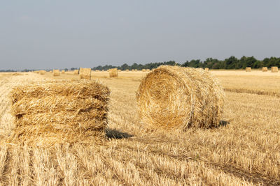 Hay bales on field against sky