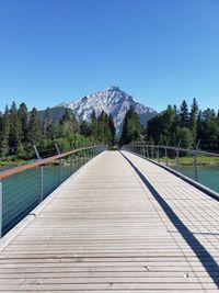 View of footbridge against clear blue sky
