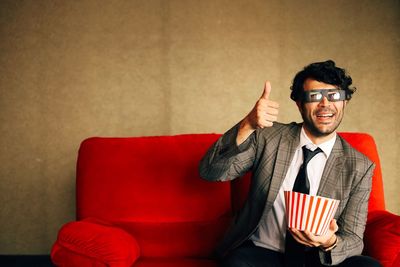 Portrait of man gesturing while wearing 3 d glasses on sofa