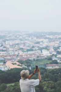 Side view of man photographing with smart phone