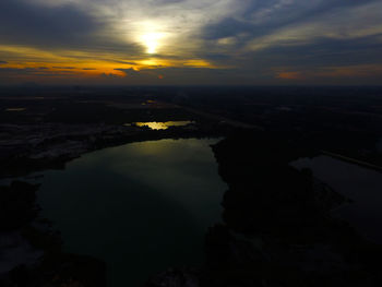 Scenic view of river against sky at sunset