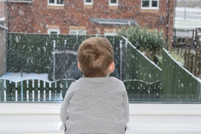 Rear view of boy watching at snowfall