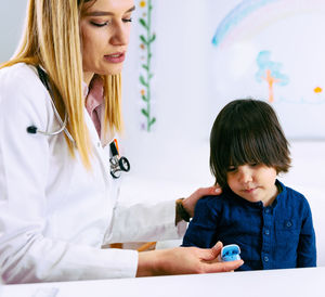 Female doctor examining boy in hospital