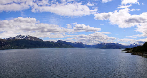 Scenic view of lake by mountains against sky