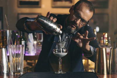 Male bartender preparing cocktail at bar counter