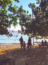 Rear view of people walking on beach