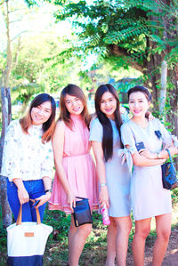 Portrait of smiling young woman standing against people