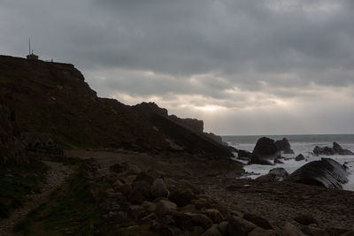 Rocks on beach against sky