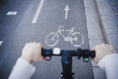 Man riding push scooter on bicycle lane