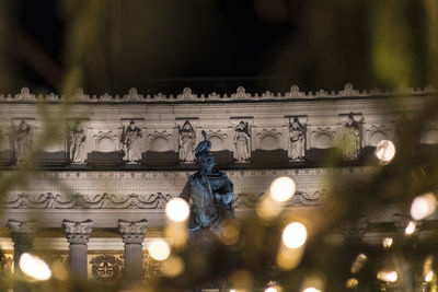 Low angle view of illuminated sculpture on building
