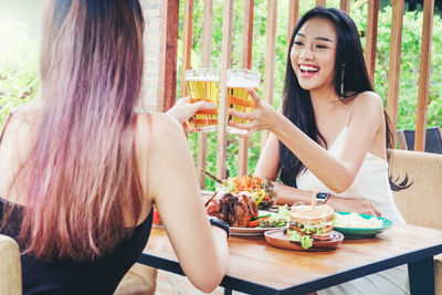 Happy young woman sitting at restaurant table