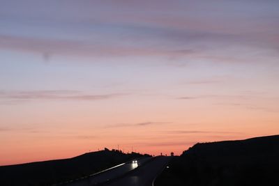 Scenic view of silhouette road against sky during sunset