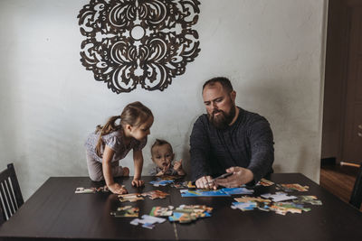 Family completing puzzle at home during isolation