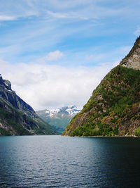 Scenic view of lake by mountains against sky