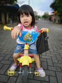 Cute girl sitting on tricycle