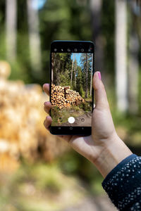 Midsection of person photographing with mobile phone