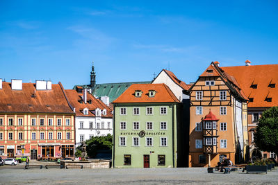 Residential buildings by road against sky