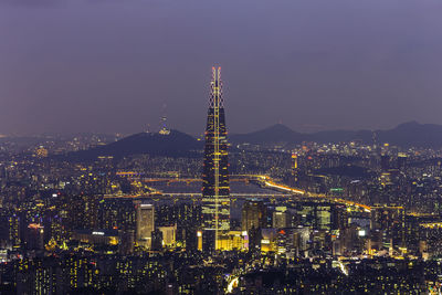 Illuminated city against sky at night