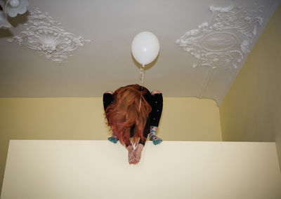 Dog sitting on balloon against gray background