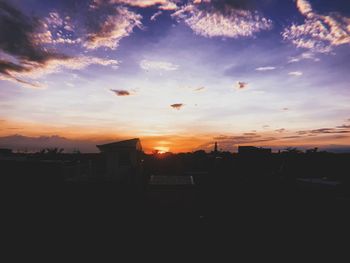 Silhouette buildings against sky during sunset