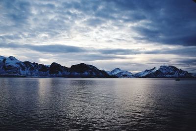 Scenic view of lake and mountains against sky during sunset