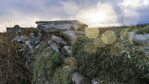 Stack of rocks on field against sky