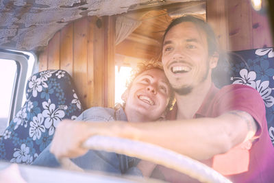 Happy couple sitting in caravan