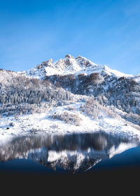 Scenic view of snowcapped mountains against blue sky