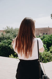 Rear view of woman standing against sky