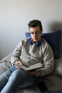 Young man sitting on sofa at home