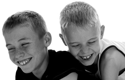 Brothers embracing while playing against clear sky