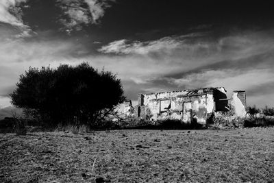 Abandoned building against cloudy sky